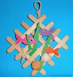 an ornament made out of popsicle sticks with fish and starfish on them