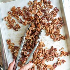 someone cutting up pecans on a baking sheet