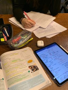 an open book sitting on top of a wooden table next to a smart phone and mouse