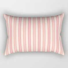 a pink and white striped pillow on a gray background