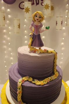 a purple cake with a princess figure on top