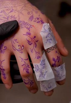 a person with tattoos on their hands and some tape wrapped around the thumbnails