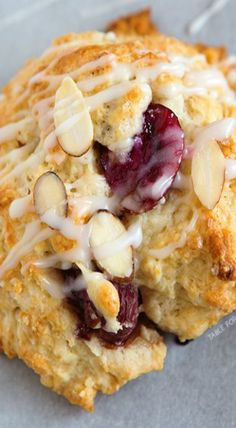 a scone with almonds, cranberry sauce and icing