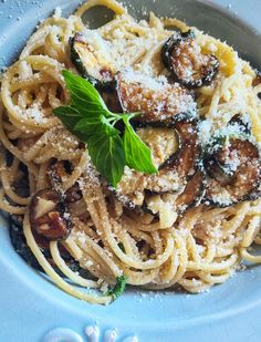 pasta with mushrooms and parmesan cheese on a blue plate