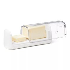 a cheese slicer sitting on top of a white counter next to a piece of cheese