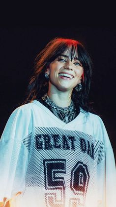 a woman standing in front of a microphone and wearing a shirt with the words great day on it