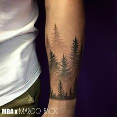 a person with a forest tattoo on their arm