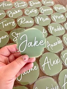 a person holding up a piece of glass with names on it and the words above them