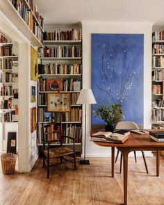 a room filled with lots of books on top of a hard wood floored floor