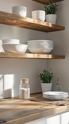 white dishes are stacked on wooden shelves in the kitchen