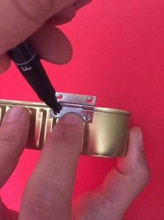 a person is using a small metal object to fix the back side of their watch