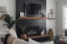 a living room with white walls and black fireplace