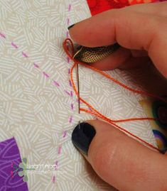 a person is stitching something on a piece of fabric