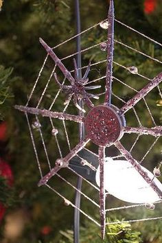 a spider web ornament hanging from a christmas tree