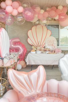 a table with balloons, cake and other items