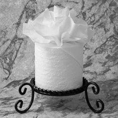 a black and white photo of a roll of toilet paper on top of a stand