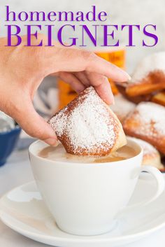 a person dipping sugar into a cup of coffee