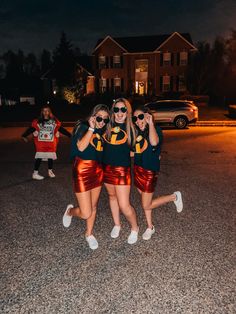 three girls in matching outfits posing for the camera with their arms around each other while wearing sunglasses