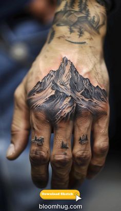 a man's hand with tattoos on it and mountains in the background, while he is showing off his mountain tattoo