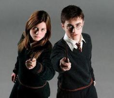 two young people dressed in harry potter costumes, one holding an umbrella and the other pointing