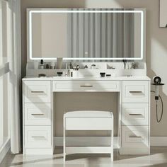 a white vanity with two sinks and a large mirror over the top that is reflecting light