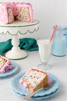 a piece of cake on a plate next to a glass of milk and a fork