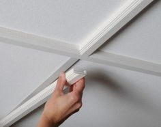 a person is painting the ceiling with white paint