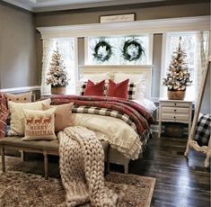 a bedroom decorated for christmas with wreaths on the window sill and plaid bedding