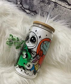 a tumbler with a cartoon character painted on it sitting on a white fur covered surface