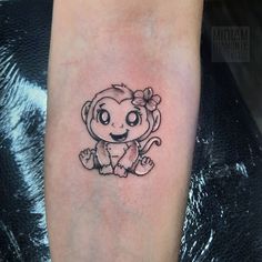 a small monkey tattoo on the arm