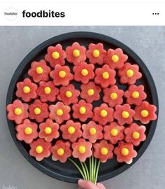 there is a black plate with red and yellow cookies on it that are shaped like flowers