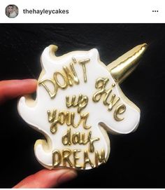 a white and gold unicorn brooch with the words don't give up your day dream