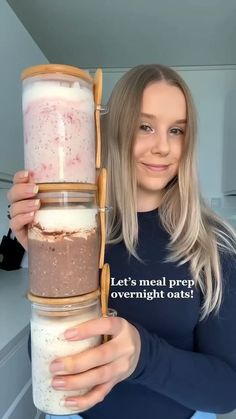 a woman is holding a large stack of food