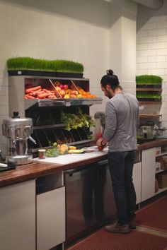 a man standing in front of a counter filled with lots of vegetables and fruit on it