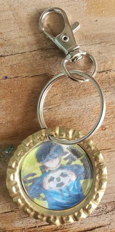 a bottle cap keychain with a painting on it