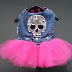 a denim bag with a pink tutu skirt and skull on the front is sitting on a black table