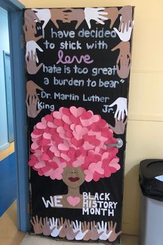 a door decorated with pink hearts and handprints on the front, saying i have decided to stick with love that is to great a burden to bear dr martin luther jr