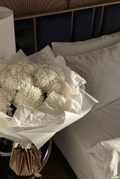 a bouquet of white flowers sitting on top of a bed