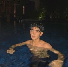 a young man is in the pool at night