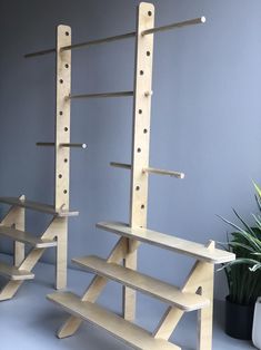 two wooden shelves are next to a potted plant