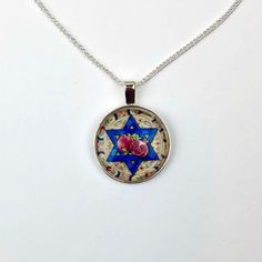 A modern take on ancient traditions, this necklace combines a modern Jewish folk art style with patterns from antiquity - showcasing two pomegranates atop a blue Magen David. Pomegranate Necklace, Pomegranate Jewelry, Jewish Star, Yom Kippur, Rosh Hashanah, Star Of David, Pomegranate, Art Style, Folk Art