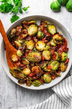 brussel sprouts and brussels sprouts in a white bowl with a wooden spoon