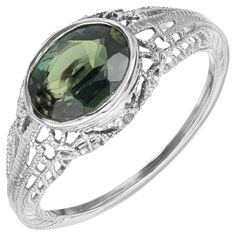 1930's Art Deco rich green sapphire engagement ring. This 1.51ct oval green sapphire is mounted sideways in a filigree 14k white gold setting. The GIA has certified the sapphire as natural, no heat. The striking green hues of the sapphire are complimented by artistic detailing of the band. A true example of the Art Deco era. 1, Natural oval Sapphire, dark yellowish green, no heat and no enhancements, approx. total weight 1.51cts. GIA certificate # 2135499508 14k White Gold Stamped: 14k 1.8 grams Art Deco Green Ring Gia Certified, Art Deco Oval Filigree Jewelry, Oval Filigree Art Deco Jewelry, Luxury Vintage Green Filigree Ring, Art Deco Green Ring, Gia Certified, Green Sapphire Engagement, Green Sapphire Engagement Ring, Gia Certificate, Yellowish Green