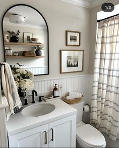 a bathroom with a toilet, sink and mirror in it's centerpieces