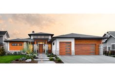 a house with two garages and landscaping in the front yard