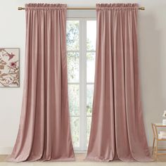 a pink curtain hanging in front of a window