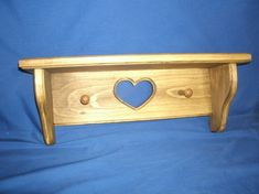 a wooden shelf with a heart cut out of it's sides on a blue background