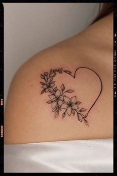 a woman's shoulder with flowers in the shape of a heart