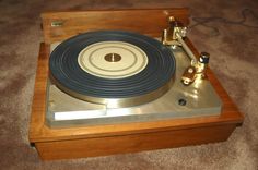 an old record player sitting on top of a wooden box with brass fittings and knobs