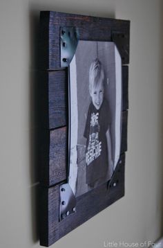 a little boy is hanging on the wall with a picture frame in front of him